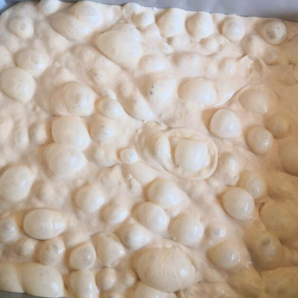 Brötchenteig nach dem Gehen mit riesige Luftblasen