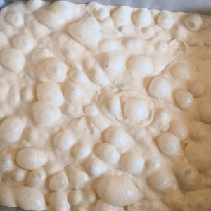 Brötchenteig nach dem Gehen mit riesige Luftblasen